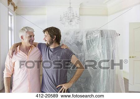 Stock Photo - Father and son hugging in living space. Fotosearch