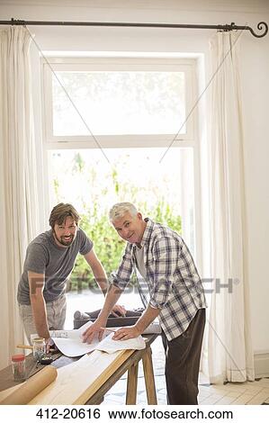 Father and son looking through documents together View Large Photo Image Stock Photograph - Father and son looking through documents together. Fotosearch