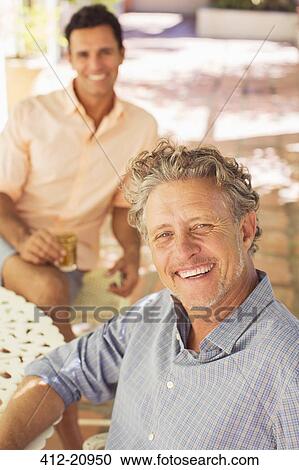 Stock Image - Father and son relaxing outdoors together . Fotosearch