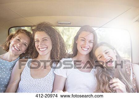 Four women sitting in backseat of car View Large Photo Image Picture - Four women sitting in backseat of car . Fotosearch