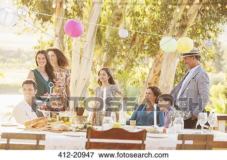 Stock Photo - Gathered family looking down the garden . Fotosearch