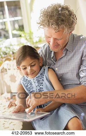 Grandfather and granddaughter using digital tablet together View Large Photo Image Stock Image - Grandfather and granddaughter using digital tablet together. Fotosearch