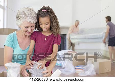 Grandmother and granddaughter going through moving box View Large Photo Image Stock Photograph - Grandmother and granddaughter going through moving box. Fotosearch