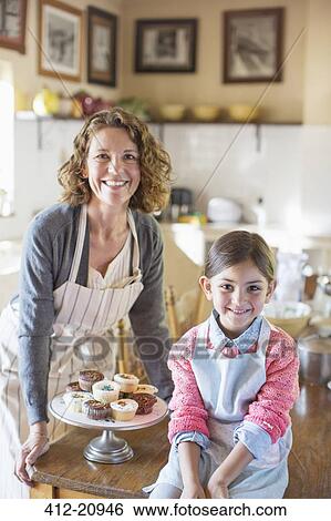 Grandmother and granddaughter smiling in kitchen View Large Photo Image Stock Photograph - Grandmother and granddaughter smiling in kitchen . Fotosearch