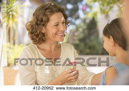 Grandmother offering granddaughter pink flower View Large Photo Image Stock Image - Grandmother offering granddaughter pink flower . Fotosearch