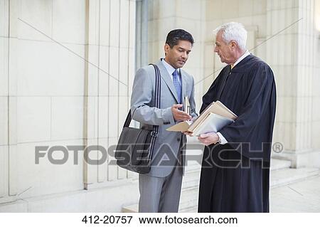 Stock Photo - Judge and lawyer examining documents in courthouse. Fotosearch