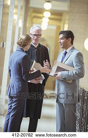 Stock Image - Judge and lawyers talking in courthouse. Fotosearch