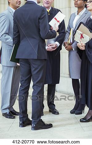 Stock Image - Judges and lawyers talking in courthouse. Fotosearch