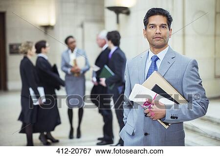 Lawyer holding legal documents in courthouse View Large Photo Image Stock Photo - Lawyer holding legal documents in courthouse. Fotosearch