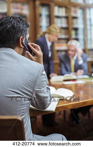 Picture - Lawyer talking on cell phone in chambers. Fotosearch