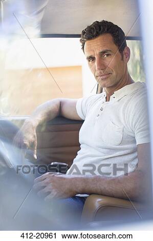 Stock Image - Man driving car on sunny day. Fotosearch