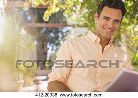 Man using digital tablet outdoors View Large Photo Image Stock Photo - Man using digital tablet outdoors. Fotosearch