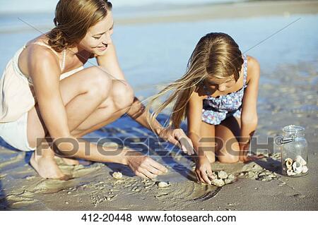 Mother and daughter playing in sand View Large Photo Image Stock Photo - Mother and daughter playing in sand . Fotosearch