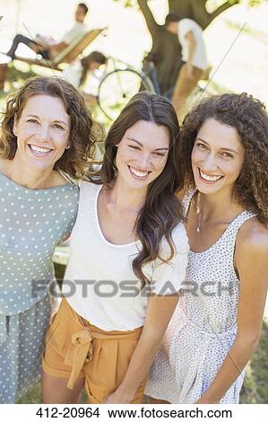 Mother and daughters hugging outdoors View Large Photo Image Picture - Mother and daughters hugging outdoors. Fotosearch