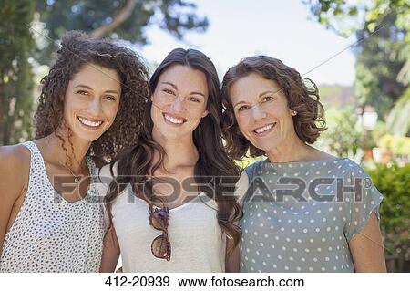 Stock Photo - Mother and daughters hugging outdoors . Fotosearch