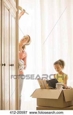 Mother painting wardrobe with daughter reading View Large Photo Image Stock Photo - Mother painting wardrobe with daughter reading. Fotosearch