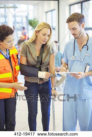 Stock Photo - Nurse and paramedic talking to patient in hospital. Fotosearch