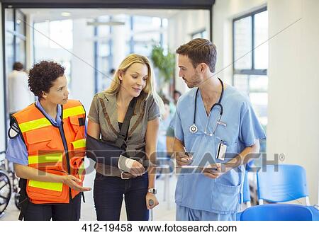 Stock Photo - Nurse and paramedic talking to patient in hospital. Fotosearch