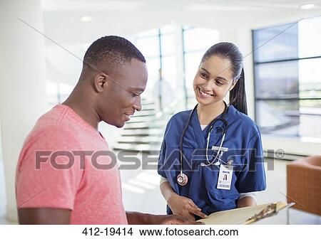 Picture - Nurse and patient reading medical chart in hospital. Fotosearch