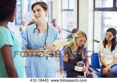 Stock Image - Nurse and patient talking in hospital. Fotosearch