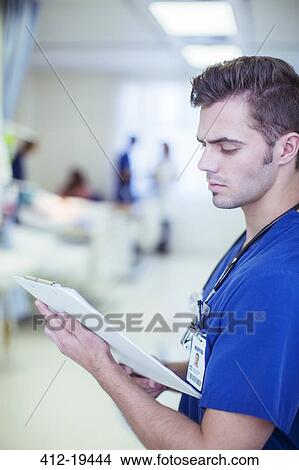 Picture - Nurse reading medical chart in hospital. Fotosearch