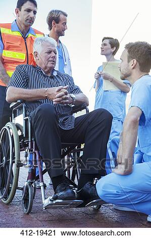 Stock Image - Nurse talking to patient outside hospital. Fotosearch