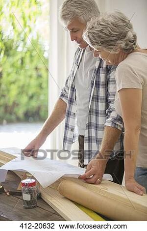 Stock Image - Older couple looking through documents together . Fotosearch