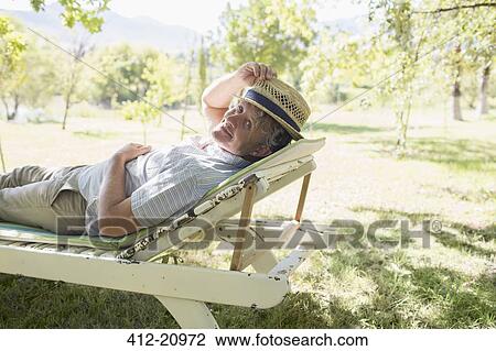 Older man relaxing on lawn chair outdoors View Large Photo Image Stock Image - Older man relaxing on lawn chair outdoors. Fotosearch