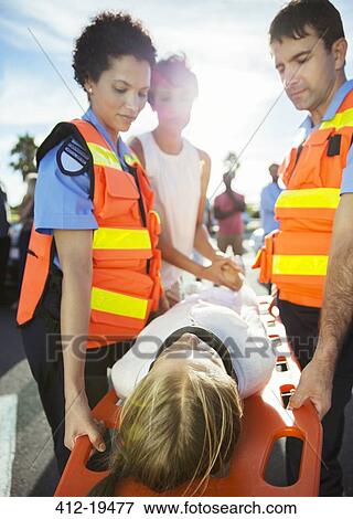 Stock Photo - Paramedics carrying patient on stretcher. Fotosearch