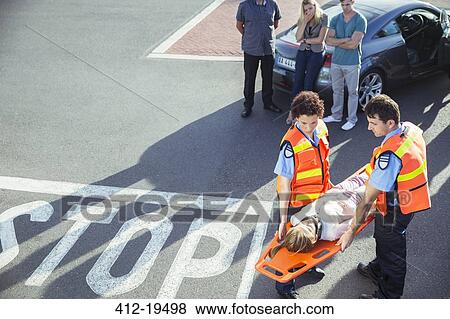 Stock Photo - Paramedics carrying patient on stretcher. Fotosearch