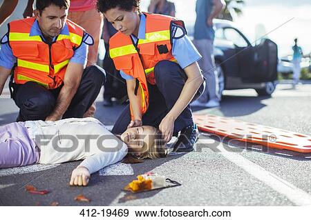 Paramedics examining injured girl on street View Large Photo Image Stock Photo - Paramedics examining injured girl on street. Fotosearch