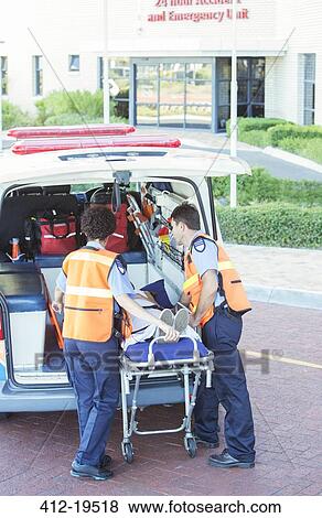 Stock Photo - Paramedics wheeling patient out of ambulance. Fotosearch