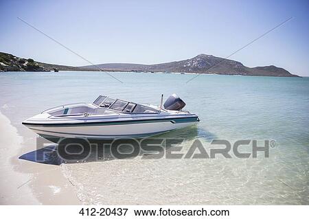 Stock Photo - Speedboat beached on shore . Fotosearch