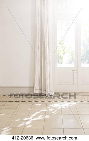 Stock Photograph - Sunlight beaming through door window in living space . Fotosearch