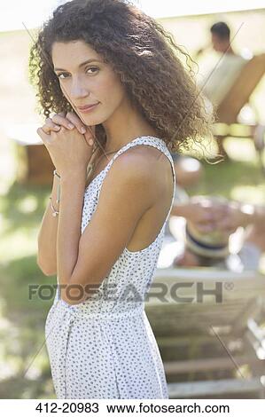 Stock Image - Thoughtful woman standing outdoors. Fotosearch