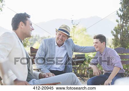 Stock Photography - Three generations of men relaxing outdoors. Fotosearch