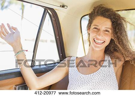 Woman feeling breeze from backseat car window View Large Photo Image Stock Photo - Woman feeling breeze from backseat car window . Fotosearch