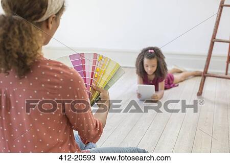 Stock Image - Woman looking through color swatches . Fotosearch