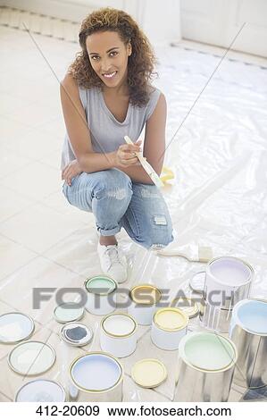 Woman squatting with paintbrush near paint cans View Large Photo Image Stock Photo - Woman squatting with paintbrush near paint cans . Fotosearch