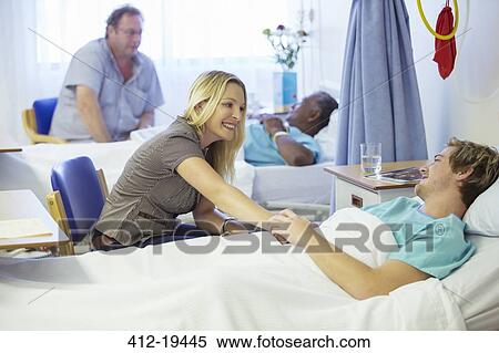 Stock Photography - Woman talking to boyfriend in hospital. Fotosearch