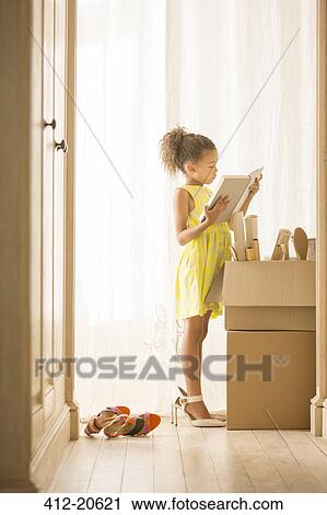 Young girl looking through moving boxes View Large Photo Image Stock Image - Young girl looking through moving boxes. Fotosearch