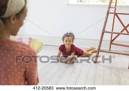 Young girl using digital tablet in living space View Large Photo Image Stock Image - Young girl using digital tablet in living space. Fotosearch