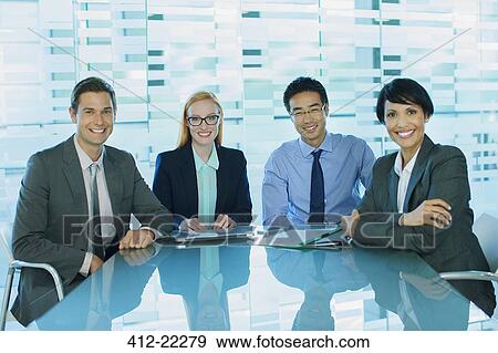 Business people gathered at table in office building View Large Photo Image Stock Photo - Business people gathered at table in office building. Fotosearch