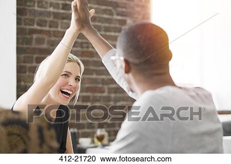 Business people high fiving at meeting in cafe View Large Photo Image Stock Image - Business people high fiving at meeting in cafe. Fotosearch