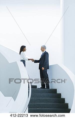 Business people shaking hands on stairs of office building View Large Photo Image Stock Image - Business people shaking hands on stairs of office building. Fotosearch