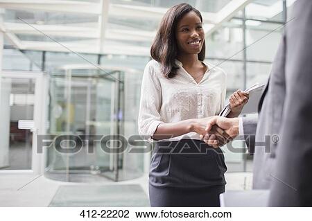 Business people shaking hands outside of office building View Large Photo Image Stock Image - Business people shaking hands outside of office building. Fotosearch