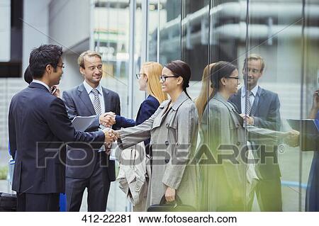 Business people shaking hands outside of office building View Large Photo Image Stock Image - Business people shaking hands outside of office building. Fotosearch