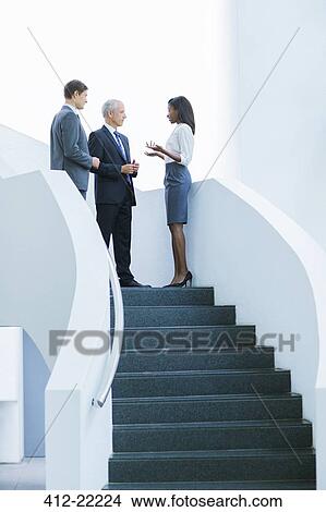 Business people talking on stairs of office building View Large Photo Image Picture - Business people talking on stairs of office building. Fotosearch