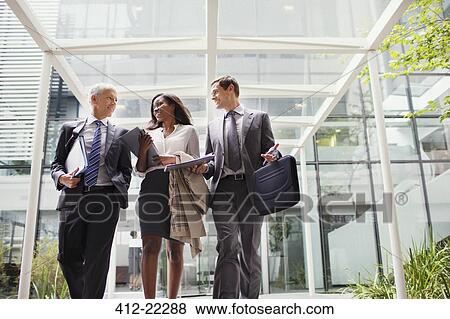 Business people walking out of office building together View Large Photo Image Stock Photo - Business people walking out of office building together. Fotosearch
