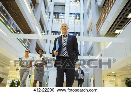 Business people walking through office building View Large Photo Image Stock Image - Business people walking through office building. Fotosearch